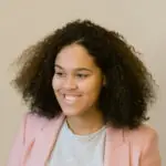 Woman in blush blazer smiling warmly