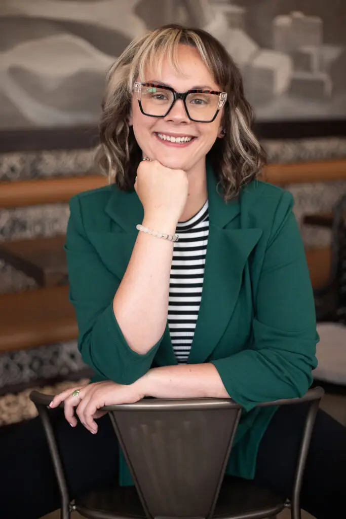 Portrait of Miranda Flinchum, owner of Mindful Messaging, smiling at a café
